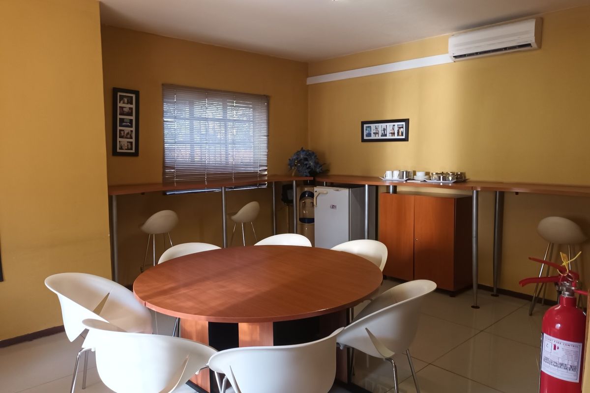 A functional living or breakout area featuring tiled flooring, a built-in counter, and a wall-mounted air conditioning unit.