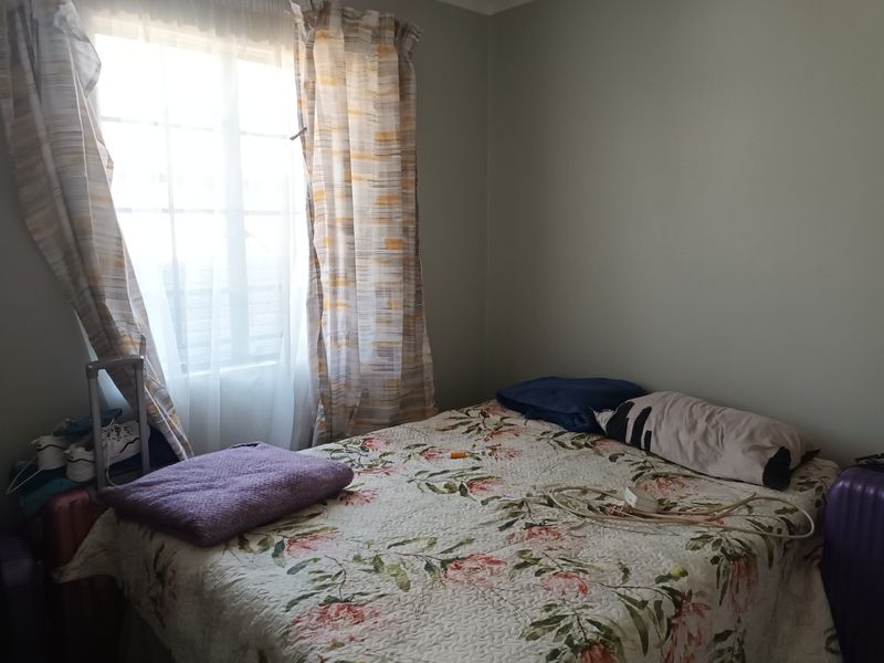 A standard bedroom featuring a window with installed curtain rails, providing natural light to the space.
