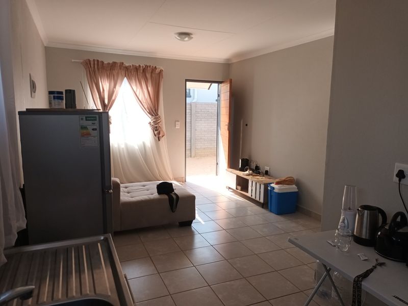 Open plan living area featuring tiled flooring and direct access to an outdoor space, providing a functional and versatile layout.
