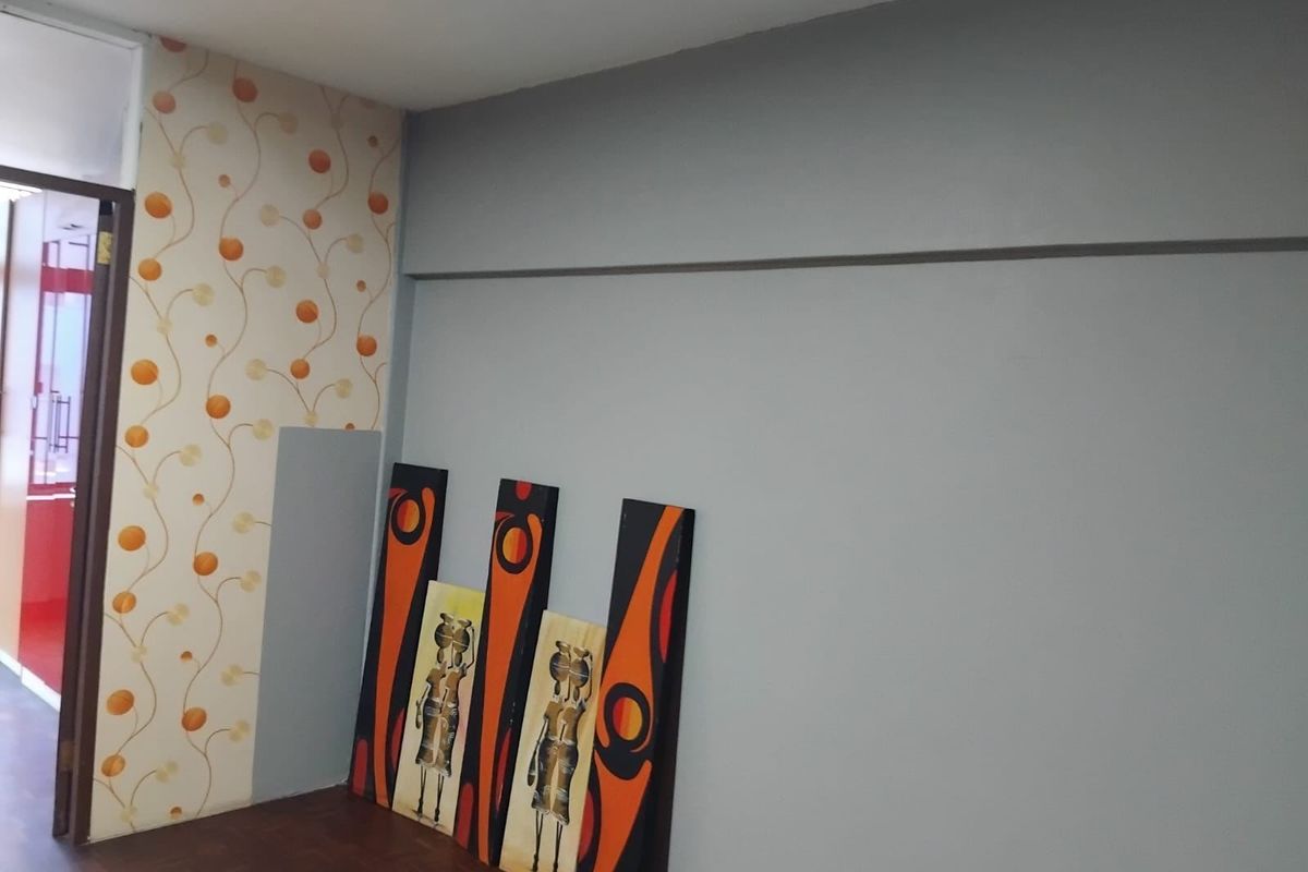 An interior living space featuring parquet flooring and a combination of painted and patterned wallpaper walls.