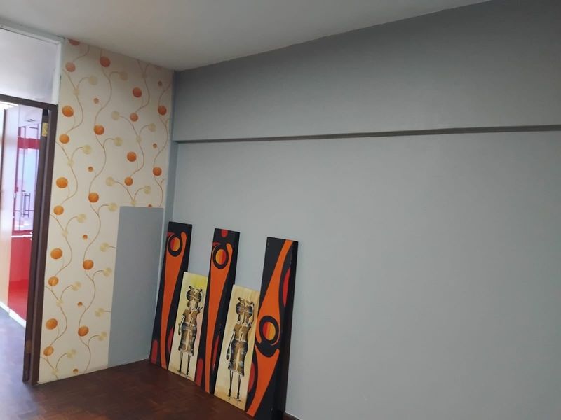 An interior living space featuring parquet flooring and a combination of painted and patterned wallpaper walls.
