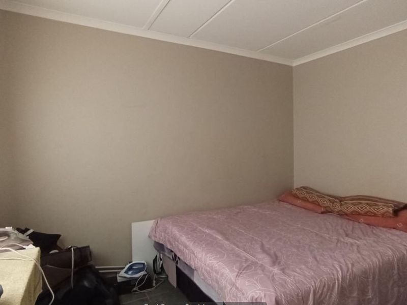 A standard bedroom featuring neutral wall tones, a coved ceiling, and built-in storage cabinetry.