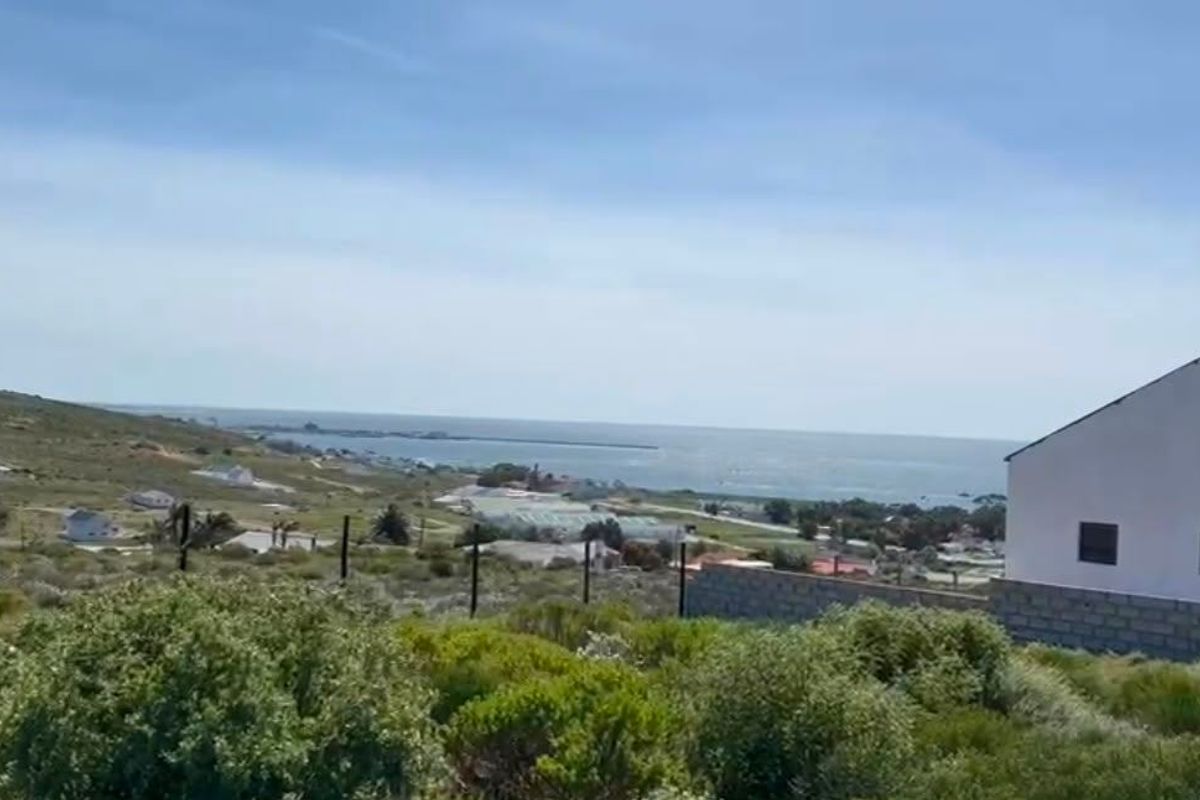 A scenic elevated view overlooking the coastal landscape and ocean, featuring natural vegetation and surrounding residential development.
