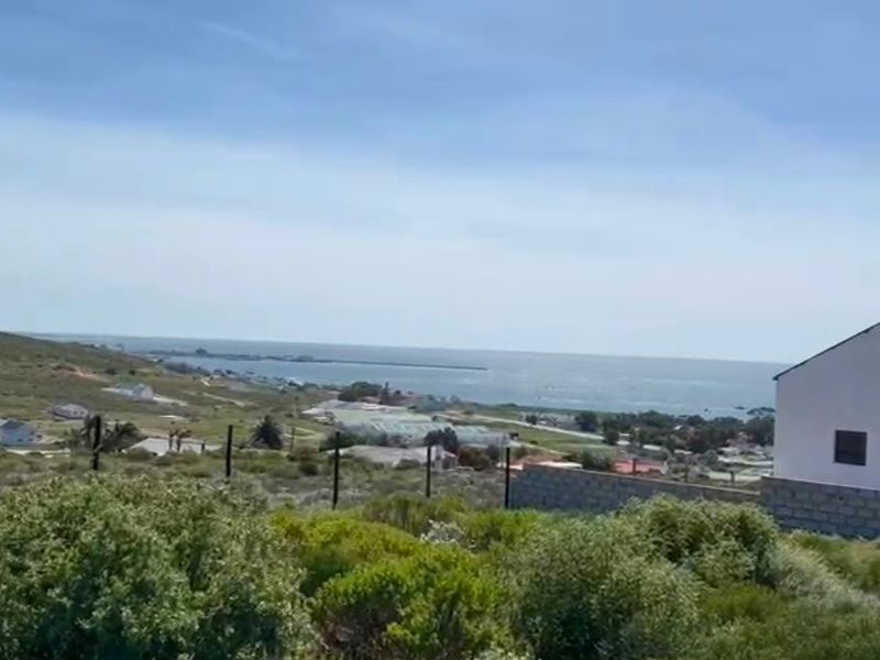 A scenic elevated view overlooking the coastal landscape and ocean, featuring natural vegetation and surrounding residential development.