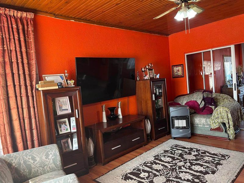 Living room featuring a timber ceiling, ceiling fan, and laminate flooring, with sliding glass door access to the rest of the home.