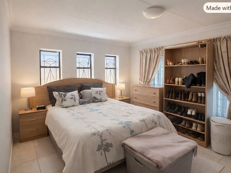 A well-maintained bedroom featuring tiled flooring, natural light through multiple windows with security bars, and neutral wall finishes.