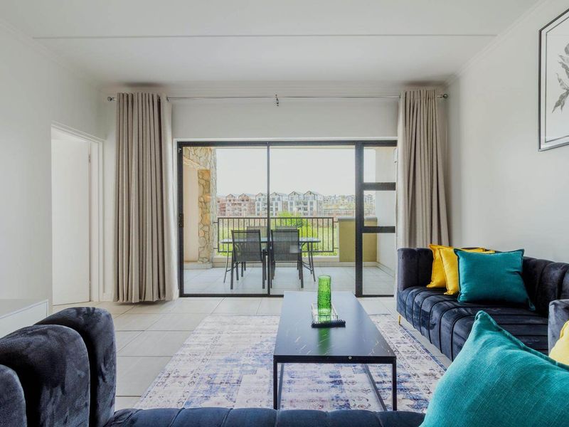 Bright and modern living room featuring large sliding glass doors that provide seamless access to the outdoor balcony area.