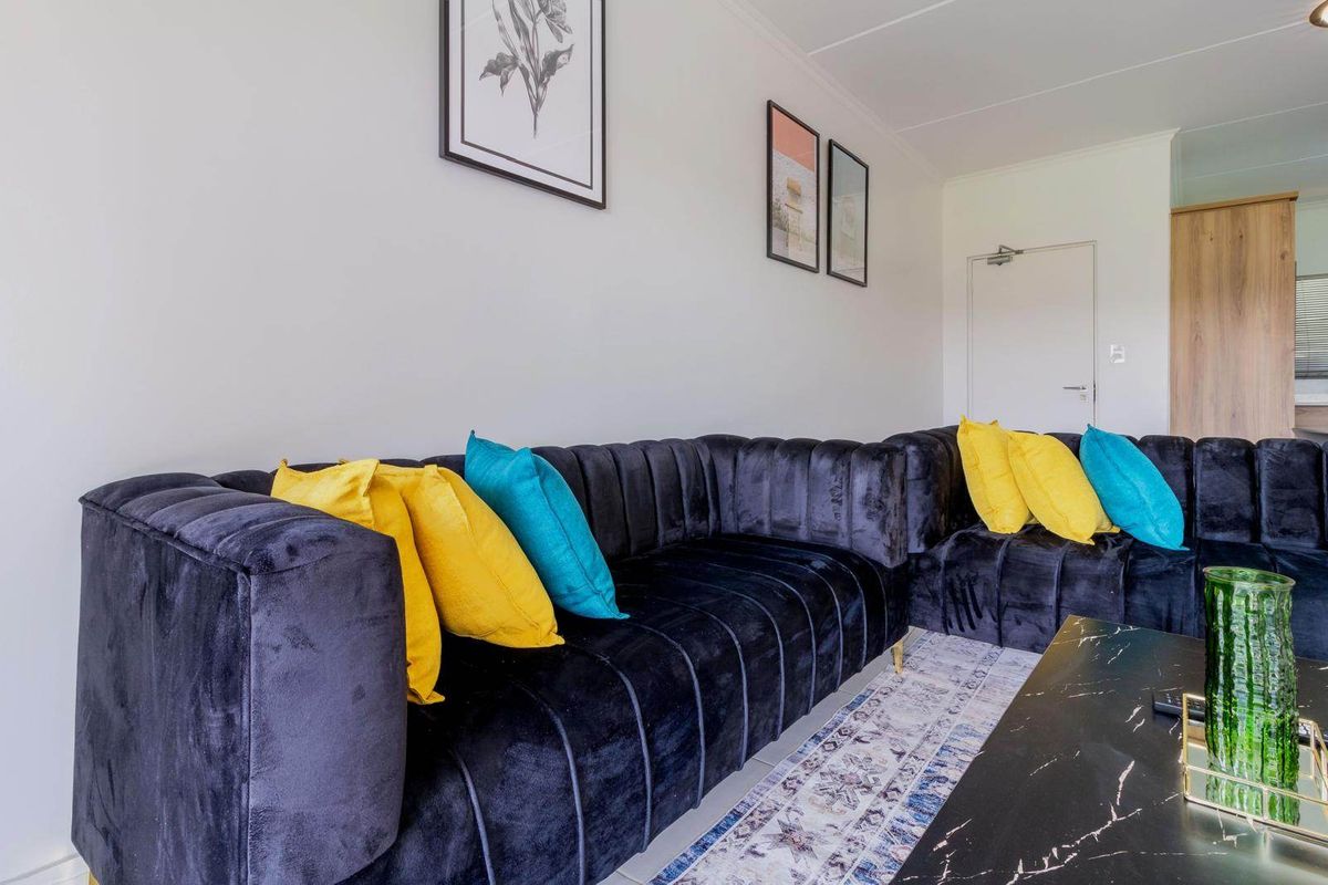 A well-maintained living room featuring neutral walls, tiled flooring, and a clean, modern interior finish.