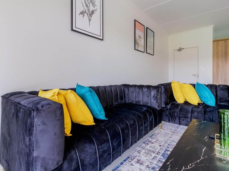 A well-maintained living room featuring neutral walls, tiled flooring, and a clean, modern interior finish.