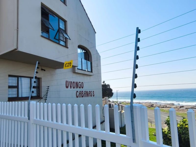 Exterior view of Uvongo Cabanas B featuring white picket fencing, electric security perimeter, and coastal proximity.