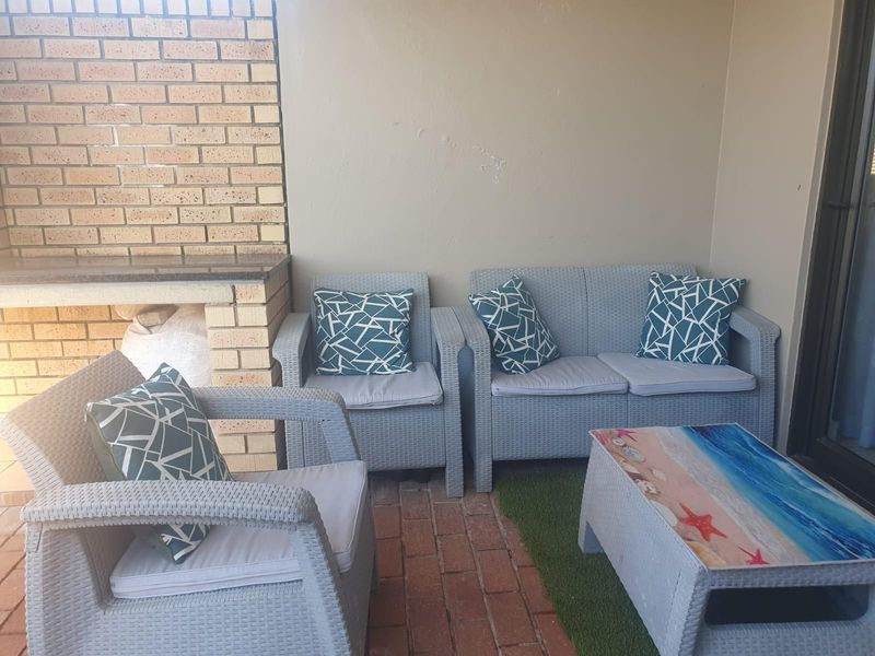 Covered patio area featuring a built-in brick braai with a granite countertop and traditional brick flooring.