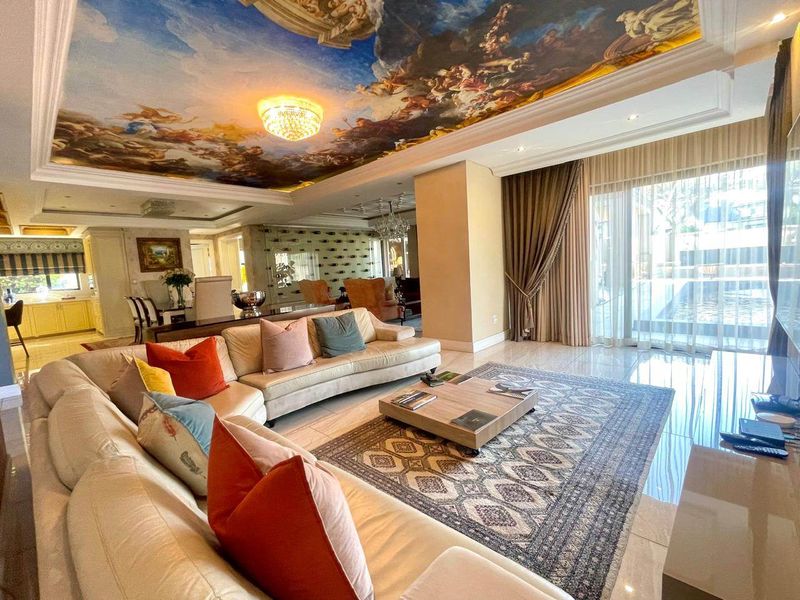Spacious open-plan living area featuring marble flooring, recessed lighting, and a striking decorative ceiling mural, with direct access to the outdoor pool area.