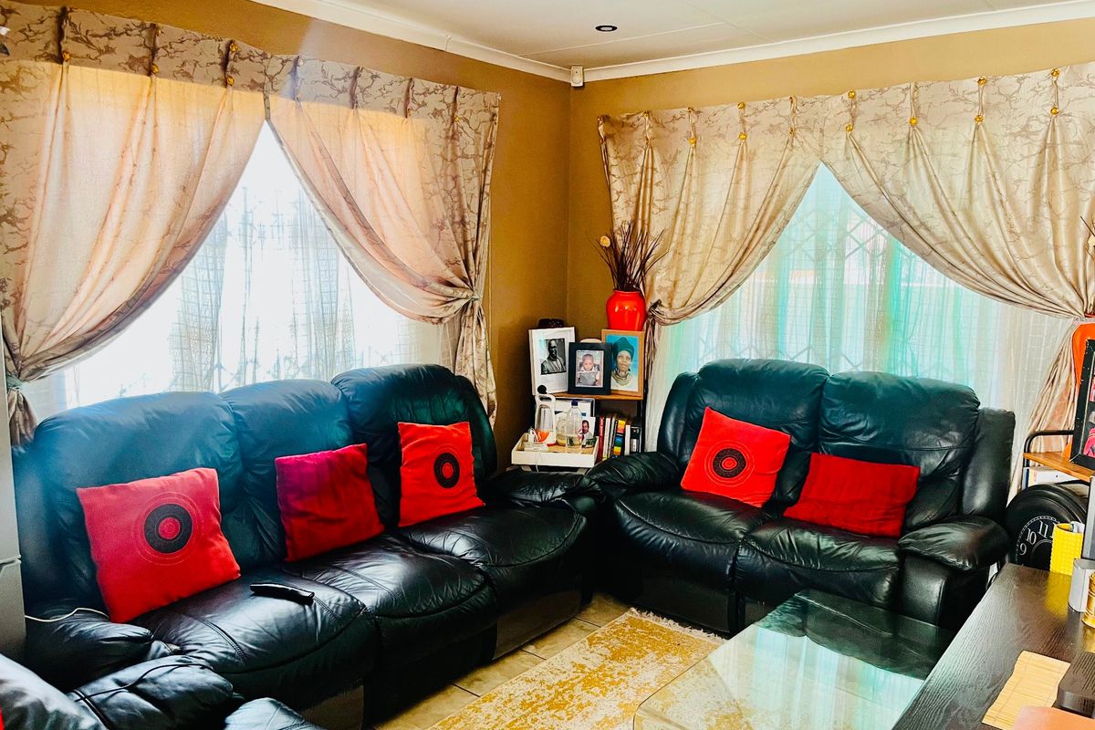 A comfortable living room featuring tiled flooring and coving, providing a functional space for relaxation.