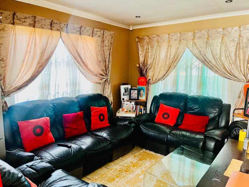 A comfortable living room featuring tiled flooring and coving, providing a functional space for relaxation.