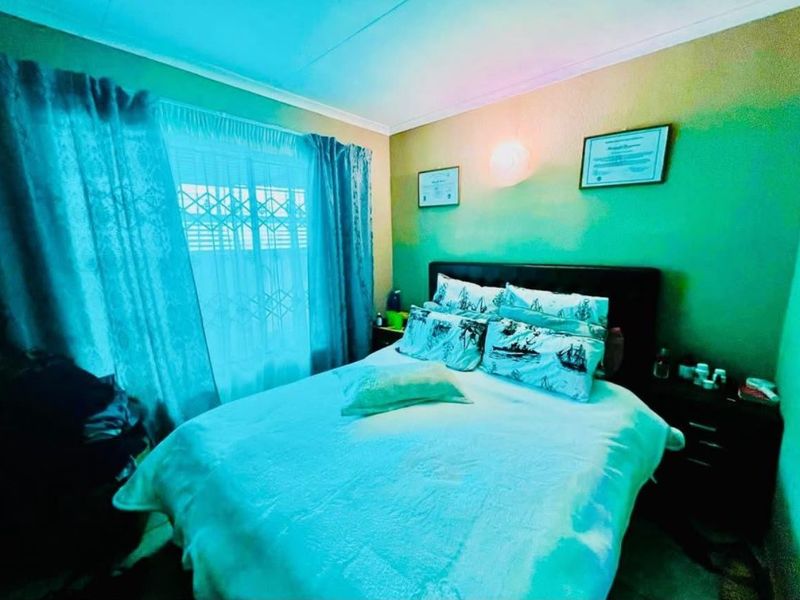 A bedroom featuring a security gate on the window and cove cornice detailing.