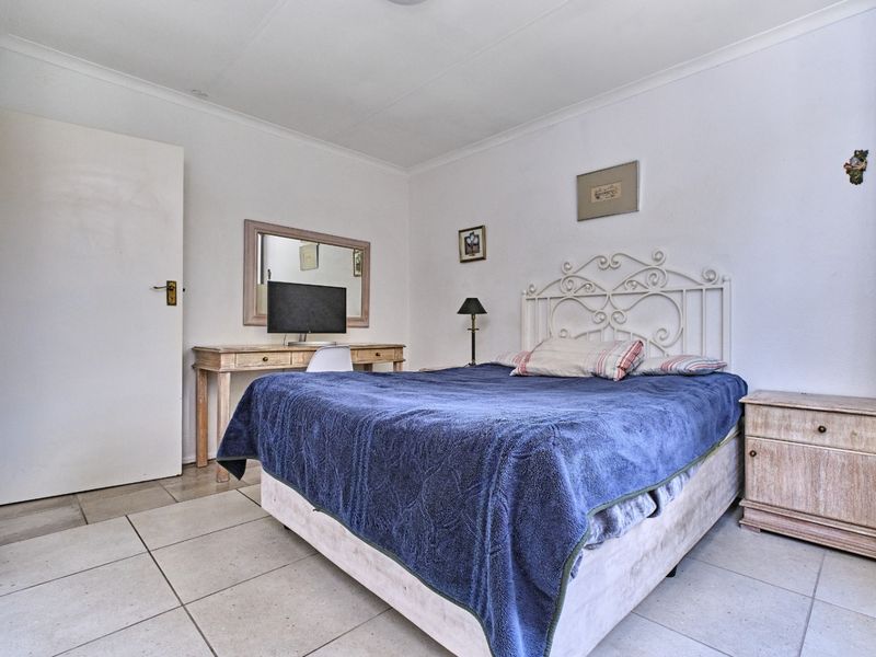A functional bedroom featuring neutral tiled flooring and coved ceiling details, providing a clean and simple space ready for personalization.