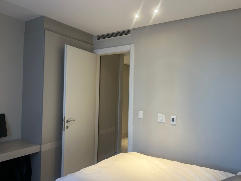 A well-maintained bedroom featuring neutral walls, built-in cabinetry, and integrated climate control systems.