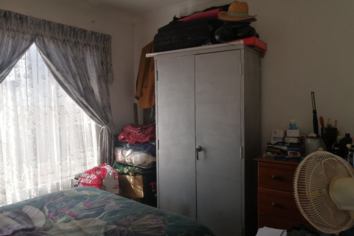 A bedroom featuring a window with curtains and space for storage, requiring cosmetic updates to improve the overall aesthetic and finish.