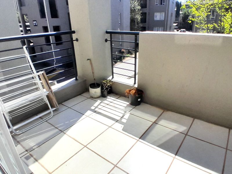 A private balcony featuring tiled flooring and a metal balustrade, offering an open outdoor space for relaxation.
