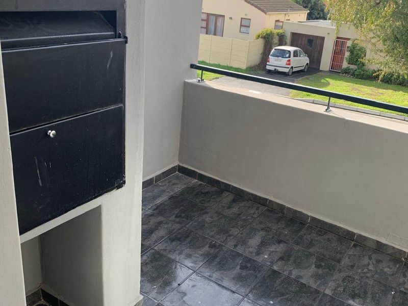 A private balcony featuring tiled flooring and a built-in braai, offering an outdoor space for relaxation and entertaining.
