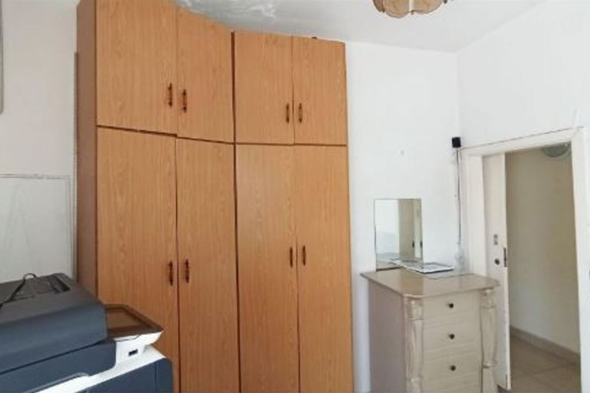 A bedroom featuring floor-to-ceiling built-in wooden wardrobes providing ample storage space.