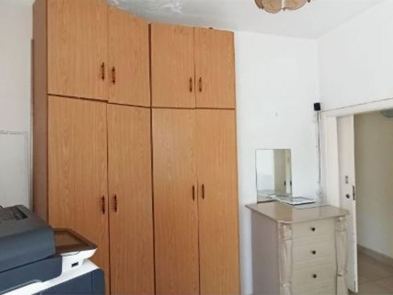A bedroom featuring floor-to-ceiling built-in wooden wardrobes providing ample storage space.