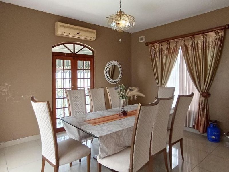 Dining room featuring tiled floors, a wall-mounted basin, and french doors leading outdoors. The space requires cosmetic attention to address wall staining.
