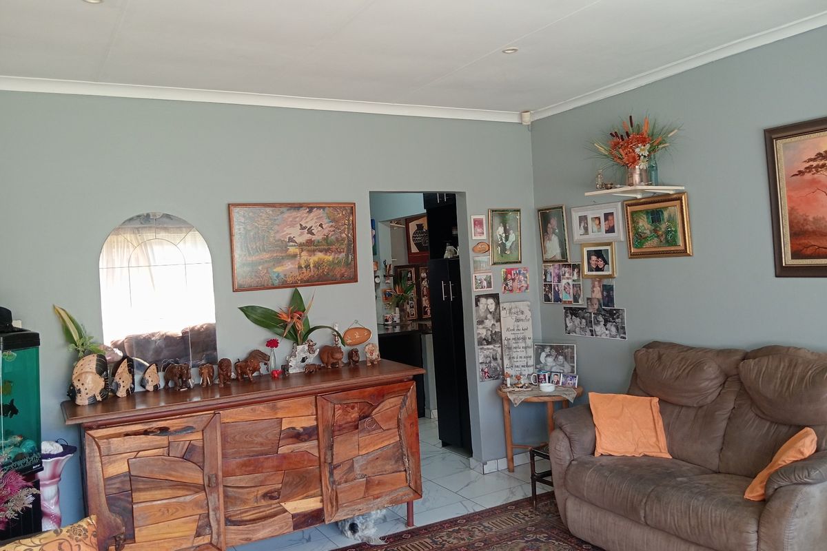 A comfortable living room featuring tiled flooring, recessed ceiling lighting, and coved cornicing, providing a functional and well-maintained living space.