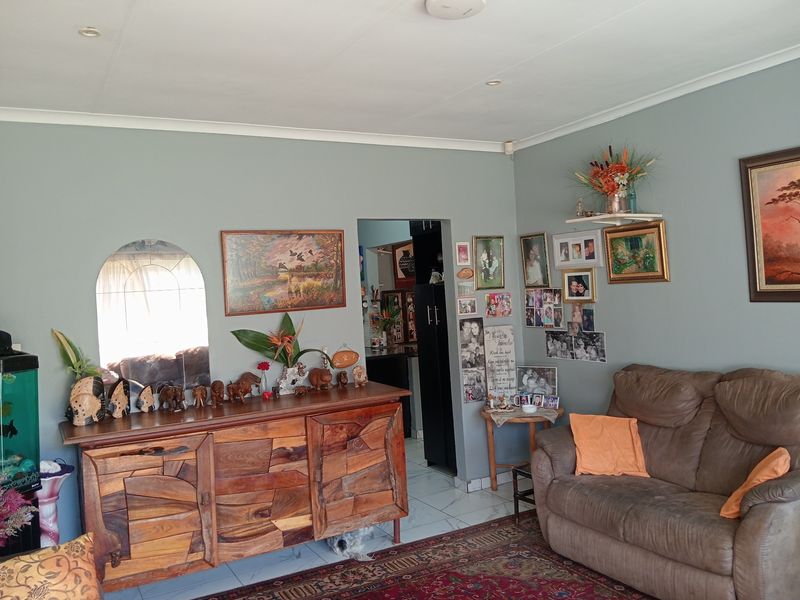A comfortable living room featuring tiled flooring, recessed ceiling lighting, and coved cornicing, providing a functional and well-maintained living space.