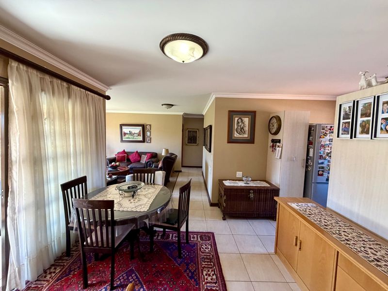 Open-plan living and dining area featuring tiled flooring, neutral wall tones, and sliding glass doors providing access to the outdoor space.