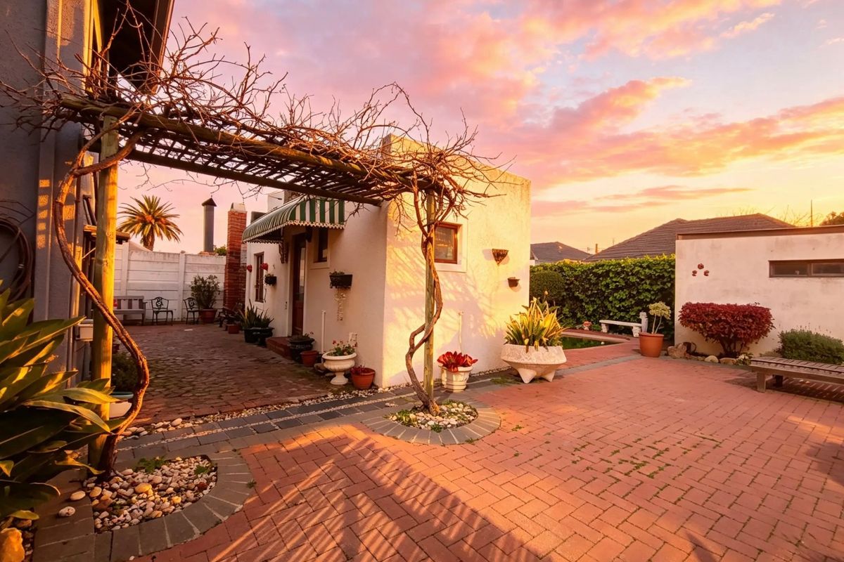 A charming rear courtyard featuring brick paving, a timber pergola, and a sunset view, providing a cozy outdoor entertainment space.