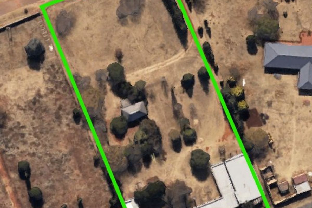 Aerial view of the farm property showing the land boundaries, existing structures, driveway access, and established trees on the plot.