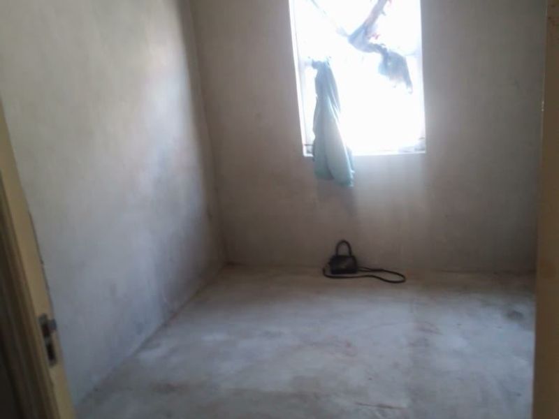 An empty bedroom featuring unfinished plaster walls and flooring, offering a blank canvas for renovation and custom interior finishes.