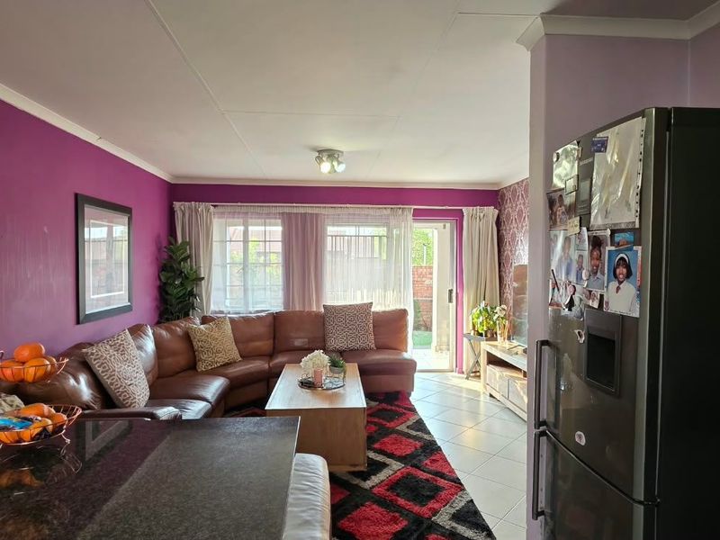 Open plan living area featuring tiled flooring, coved ceilings, and a sliding glass door providing access to the exterior.