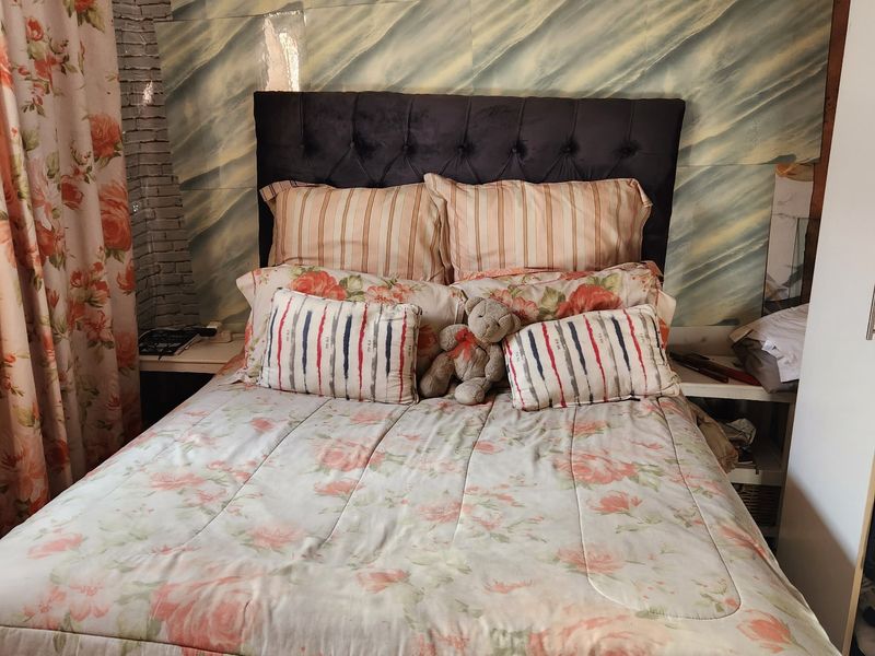 A bedroom featuring built-in bedside shelving and decorative wall paneling, offering a functional space ready for modern updates.