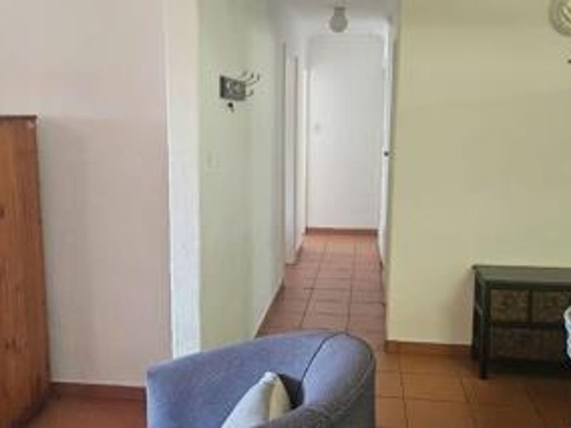 A view of the interior hallway featuring tiled flooring and access to adjacent rooms within the townhouse.