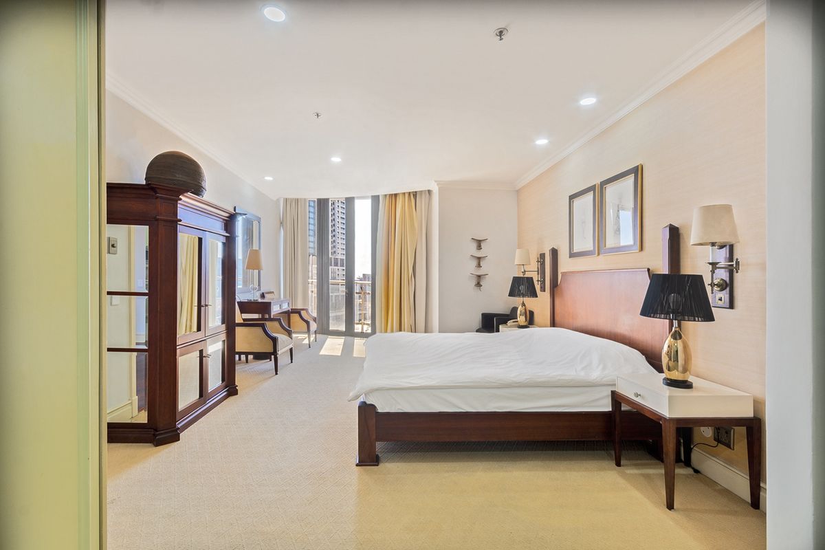 Spacious bedroom featuring neutral carpeting, recessed lighting, and direct access to a private balcony through sliding glass doors.