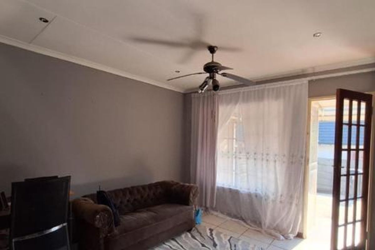 A living room featuring tiled flooring, a ceiling fan, recessed lighting, and a french door providing access to the exterior.