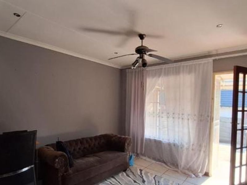 A living room featuring tiled flooring, a ceiling fan, recessed lighting, and a french door providing access to the exterior.