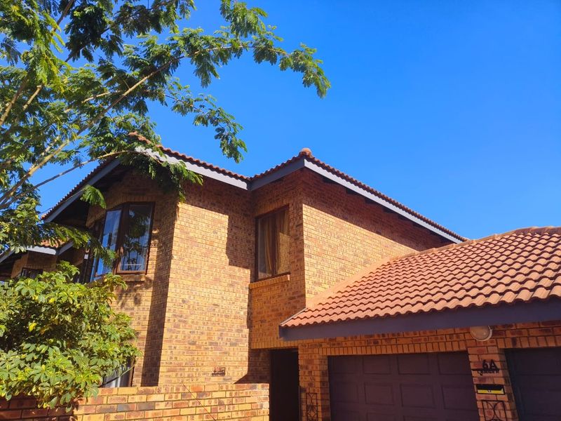 Front elevation of a double-story face brick house featuring a tiled roof and integrated garage.