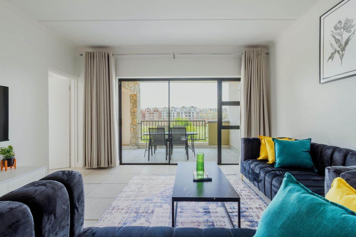 Bright living room featuring tiled flooring and a large sliding glass door providing direct access to the balcony.