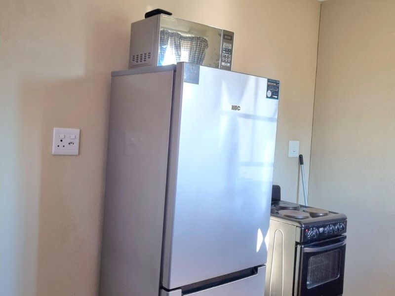 A functional kitchen area featuring tiled flooring and standard electrical wall sockets, providing a basic foundation for culinary activities.