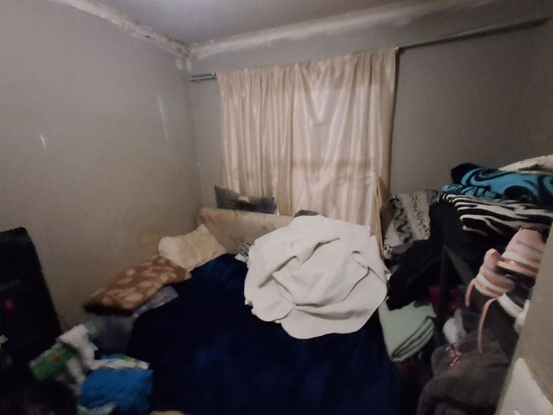A small bedroom space requiring cosmetic attention, including wall repairs and repainting to improve the overall condition of the room.