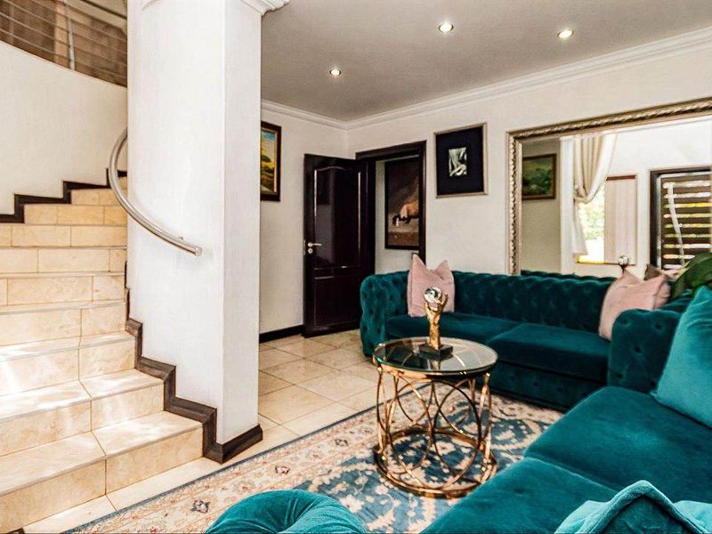 A well-maintained living area featuring tiled flooring, recessed lighting, and a tiled staircase with a modern stainless steel handrail.