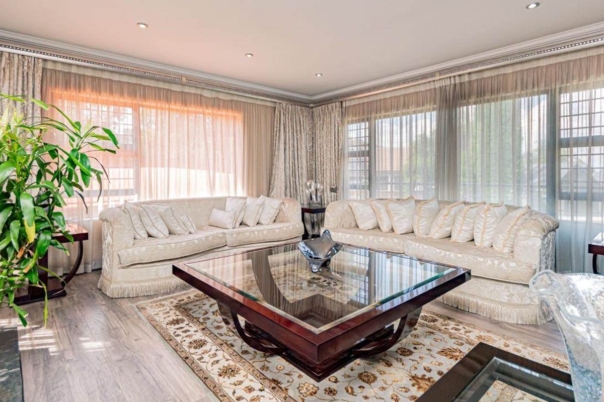 Spacious living room featuring large windows, recessed downlighting, and modern laminate flooring, creating a bright and inviting atmosphere.