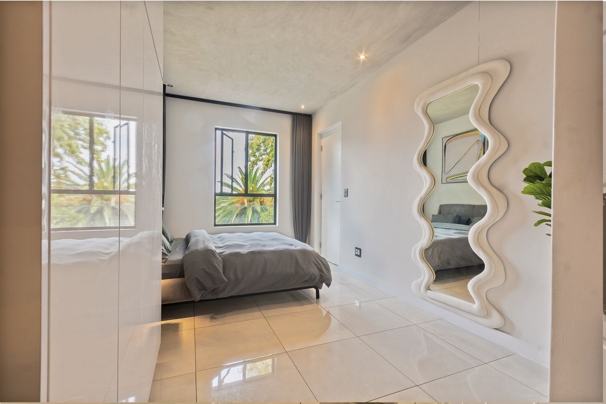 Modern bedroom featuring high-gloss built-in cupboards, polished tile flooring, and recessed lighting, offering a clean and contemporary living space.