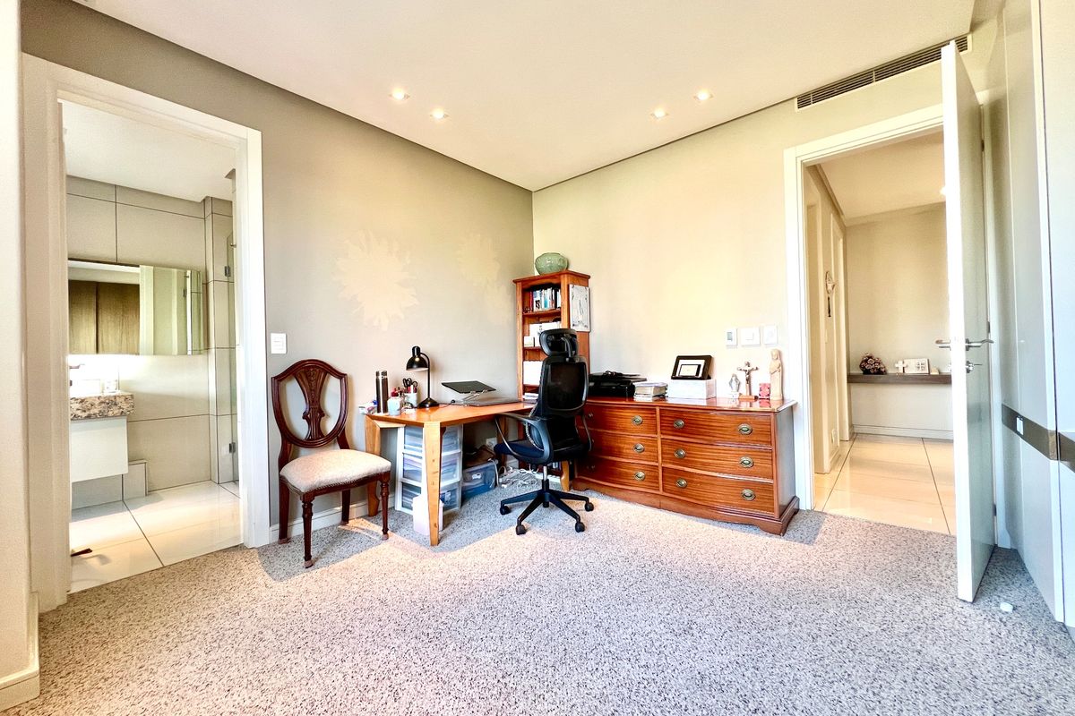 Spacious bedroom featuring neutral carpeting, recessed lighting, ducted air conditioning, and direct access to an en-suite bathroom.