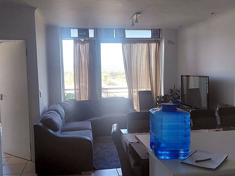 Open-plan living and dining area featuring tiled flooring and direct access to a balcony with natural light.