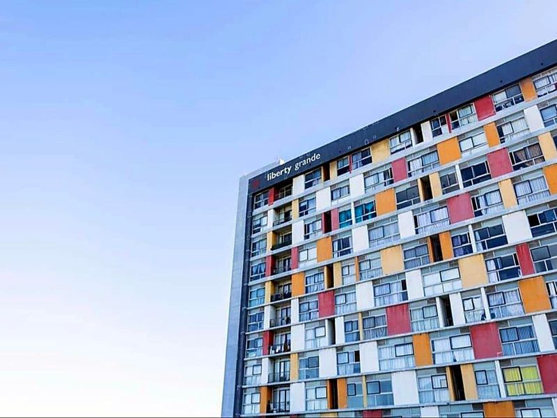 Exterior view of the Liberty Grande apartment building, showcasing its multi-colored facade and structured window layout.