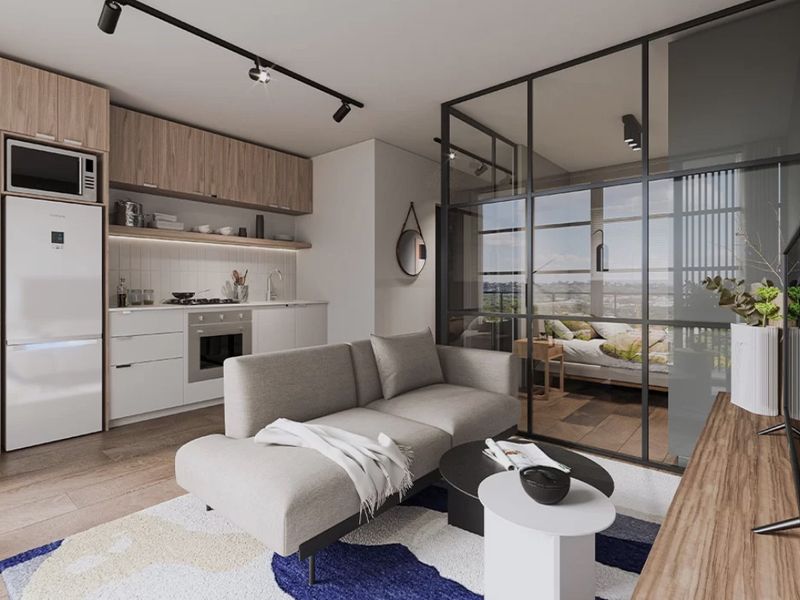 Modern open-plan apartment featuring a sleek kitchen with integrated appliances and a stylish glass-partitioned bedroom area, offering a contemporary and functional living space.